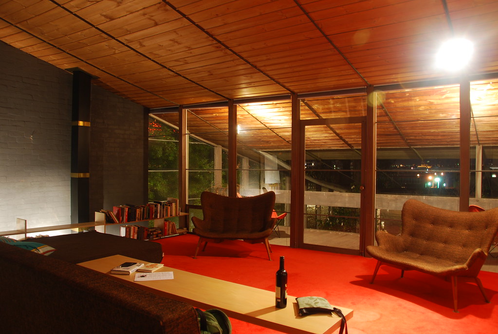 Renovated living room with a wood plank ceiling, red floor and wide windows